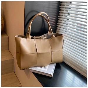 Close-up of khaki woven tote bag with large capacity and fine leather texture