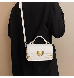 Back view of model wearing white quilted crossbody bag with gold hardware and chain detail