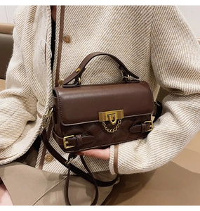 Detailed view of dark brown quilted leather bag with vintage gold hardware on model