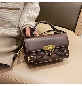 Close-up of brown quilted leather handbag with gold metal hardware and chain detail