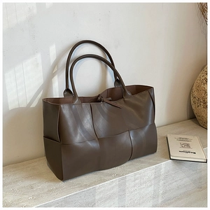 Detailed view of dark brown woven tote bag made of high-quality matte leather