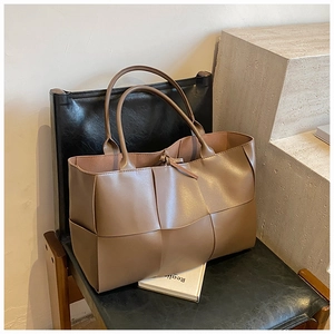 Detail of premium woven leather tote bag in dark brown with a chic tie closure