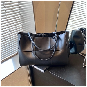 Detailed close-up of premium black woven tote bag with large capacity and matte leather texture