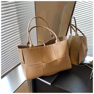 Detail of light brown woven faux leather tote bag with long handles and tie closure