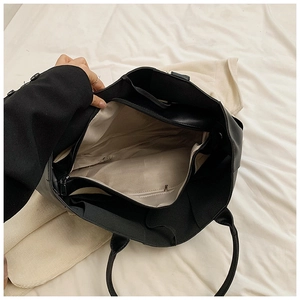 Interior view of black woven tote bag showing large capacity and multi-layer zipper pockets