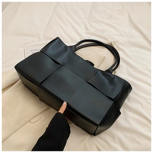 Close-up of black woven leather tote bag texture with large capacity design