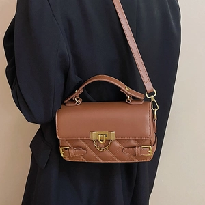 Elegant brown quilted leather handbag with bronze hardware and adjustable strap
