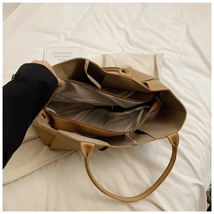 Detail of spacious interior with multi-compartment zipper pockets on woven tote bag