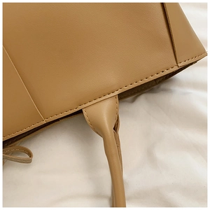 Close-up of khaki woven tote bag showing precise stitching and premium PU leather texture