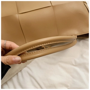 Detail shot of khaki woven leather tote bag with thick handles and reinforced stitching