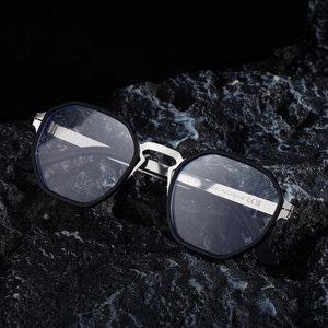 Polarized octagonal sunglasses for men with silver metal frames on dark stone background