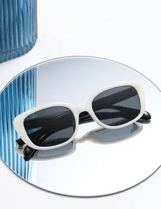 Detail of square white sunglasses with polarized lenses reflecting on a mirror surface