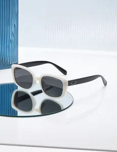 Detail of square ivory white sunglasses with black temples and silver oval accents