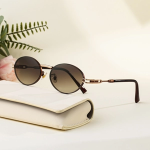 Retro round sunglasses with brown gradient lenses and bronze metal frame on a leather case