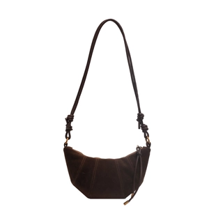 Dark brown suede croissant bag with stitched panels and knotted strap on white background