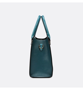 Detail view of dark teal tote bag with lychee grain leather and crocodile pattern handles