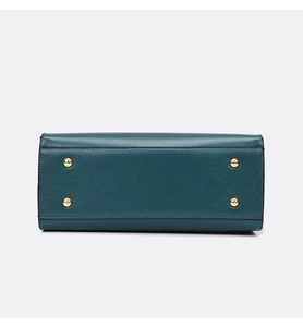 Detail of dark green pebble leather bag bottom featuring four protective gold metal studs