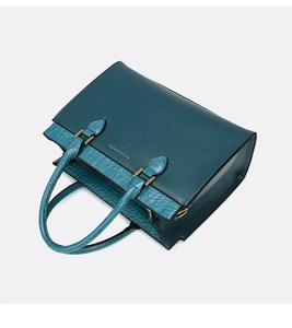 Detail view of teal tote bag featuring lychee and crocodile textures with gold hardware