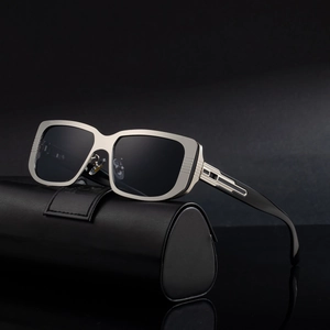 Silberne quadratische Sonnenbrille mit schwarzen Gläsern und Lederetui auf dunklem Grund