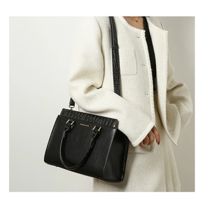 Close-up of black PU leather tote with crocodile pattern texture and golden logo