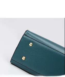 Detail view of high-quality lychee grain leather and golden metal feet on tote bag