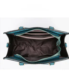 Internal view of crocodile-pattern tote bag showing zippers and brown fabric lining