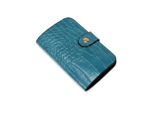 Peacock blue crocodile embossed clutch bag with a round gold button closure on white background