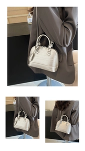 Detail of silver shell bag showing metallic texture, twin handles and crossbody strap