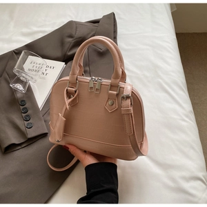Detail of light pink shell bag with crocodile texture and silver hardware