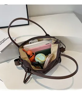 Macro view of spacious dark brown tote bag interior holding laptop and umbrella