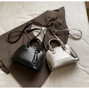 Close-up of black and silver shell bags with crocodile pattern and silver hardware