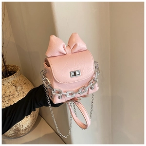 Detail of pink bow handbag with pleated texture and silver twist lock mechanism