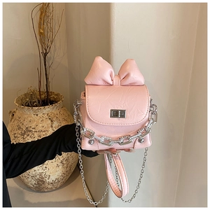 Macro detail of pink mini box bag with large bow, silver chain and metal turn-lock
