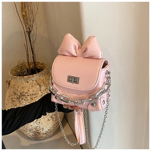 Detail of a pink mini bow box bag featuring pleated texture and silver chain strap