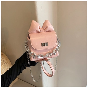 Detailed view of pink box bag with oversized bow, silver chain, and metal buckle