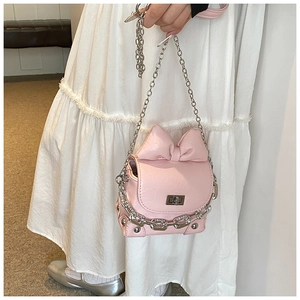 Detail of pink mini bow handbag with chunky silver chain and textured leather finish