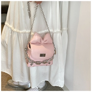 Detail of pink mini box bag with large bow and decorative silver chunky chain