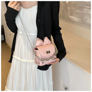 Detailed shot of pink mini box bag with oversized bow and chunky silver chain decor