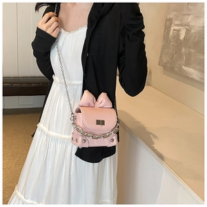 Detail of pink bow handbag showing shiny pleated texture and silver twist lock
