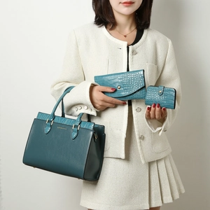Three-piece teal leather tote bag set with crocodile texture and matching wallets
