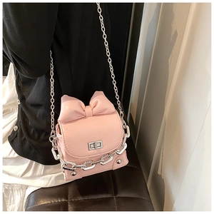 Detailed view of pink mini bow crossbody bag with silver chain and glossy finish