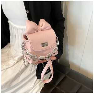 Detail of pink mini bow bag with wrinkled faux leather texture and silver chain strap