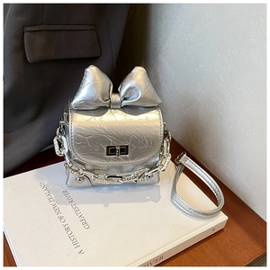 Detail of silver pleated mini box bag with large bow and sparkling chain handle