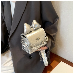 Detail of silver metallic wrinkled leather bag with large bow and chunky chain strap