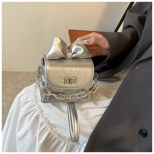 Detail of silver mini box bag with bow decoration and metallic chain strap