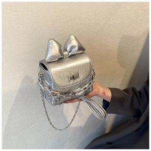Detail of silver mini box bag with large metallic bow and metal turn-lock closure