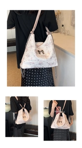 Close-up of butterfly print tote with gold bow buckle and adjustable chain strap