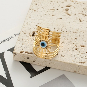 Adjustable hollow evil eye ring with multi-layered gold bands on a textured stone