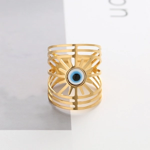 Detailed macro view of the gold hollow-out wide band ring with a blue evil eye emblem