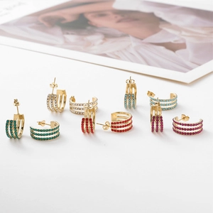 Macro shot of 5 pairs of gold C-shaped earrings with colorful sparkling rhinestones